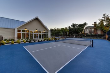 Tennis Courts with Fitness Center Exterior, Trees, and Bushes